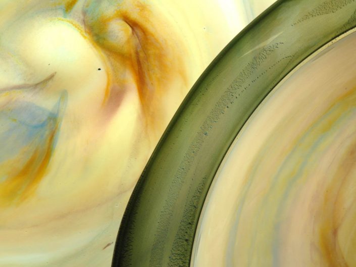 closeup photography yellow and green glass art trays with abstract swirls of color